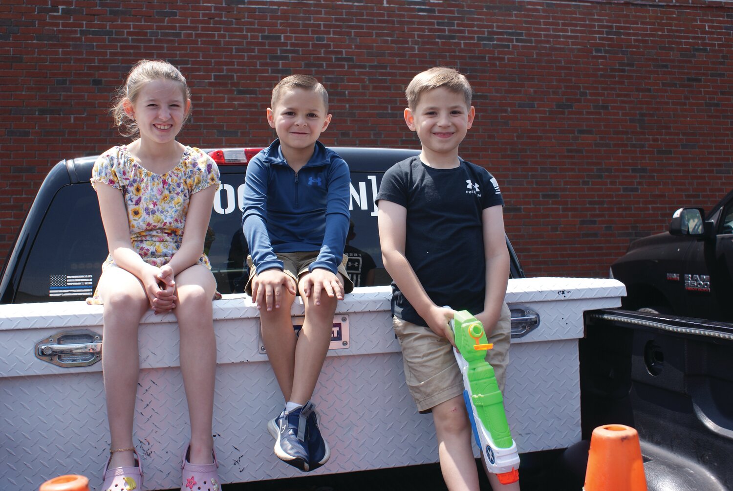 SONY DSCENJOYING THE SHOW: (Left to Right) Mackenzie Iacone(9), Philip DiSano (6) and Jonathan Iacone (6) happily watch as Zuess grabs on to Officer O’Donnell and won’t let go until the command is given as they sit in the back of the Iacone family pickup truck with the perfect view just off of Rolfe Square.  (Photos by Steve Popiel)